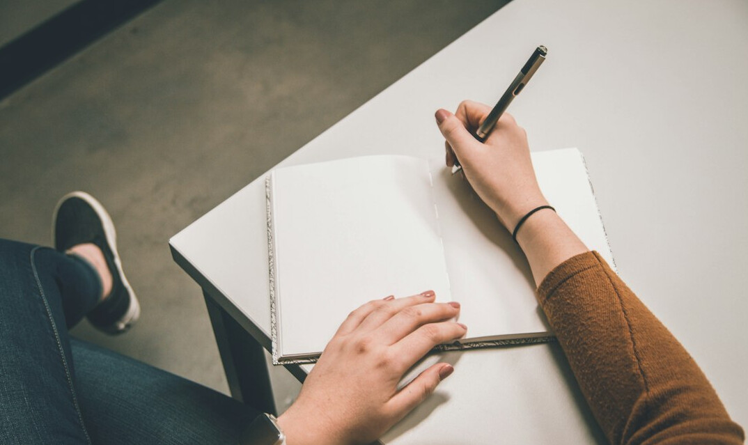 person writing goals in notebook